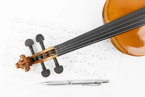 Wooden Violin Neck with Notes on the sheet music and Pencil