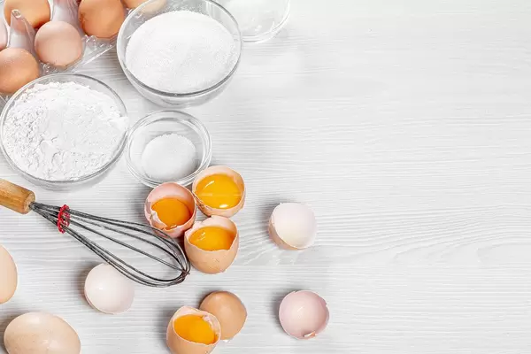 Wooden white table with ingredients for making biscuit