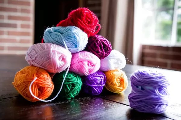 Wool yarns stacked as a pyramid on a black table