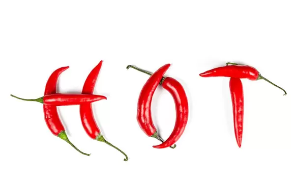 Word hot made from red chili peppers on white