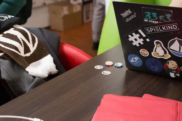 Wordpress Broschen, Schal und ein ThinkPad mit vielen Stickern auf dem Rückdeckel