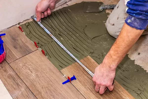 Worker measures with tape the parts that need work