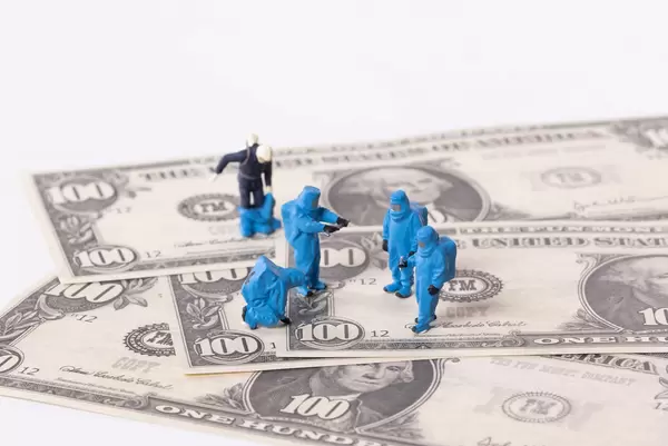 Workes in blue protective suits on Dollar banknotes
