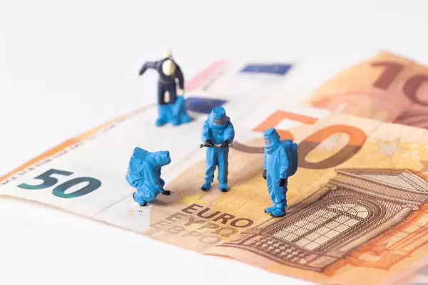 Workes in blue protective suits on Euro banknotes