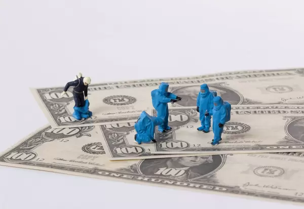 Workes in protective suits on Dollar banknotes