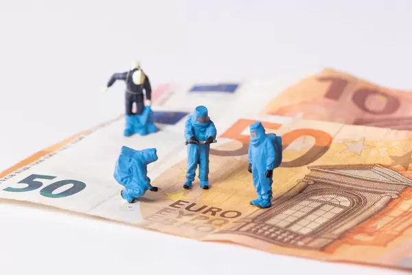 Workes in protective suits on Euro banknotes