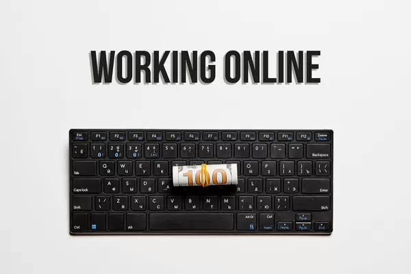 Working online concept with pc keyboard and us dollar bill