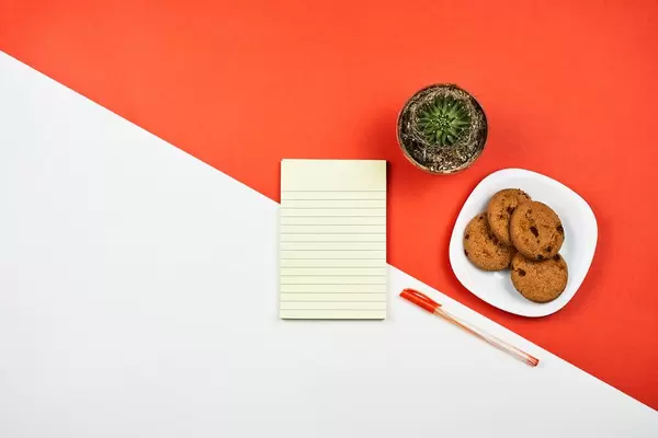 Workplace with a notepad on red and white background