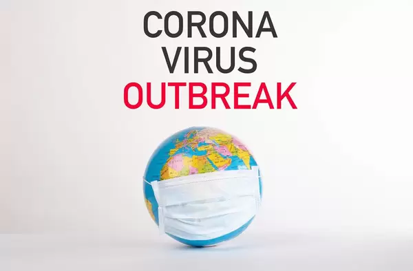 Worte Corona Virus Outbreak über einer Weltkugel mit Gesichtsmaske auf weißem Hintergrund
