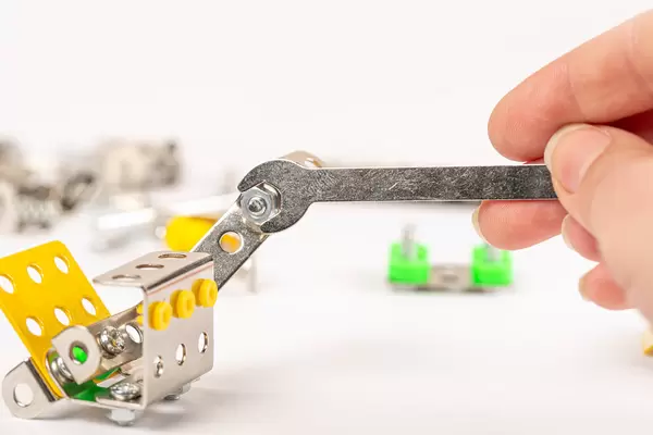 Wrench with a nut, fastening metal parts of the constructor