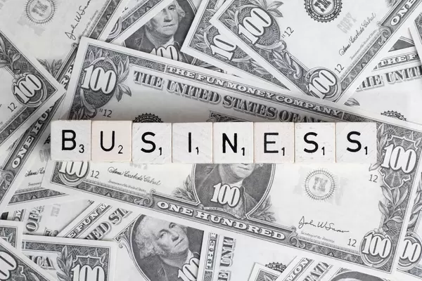 Würfel bilden das Wort BUSINESS (Geschäft) auf US-Dollar Banknoten