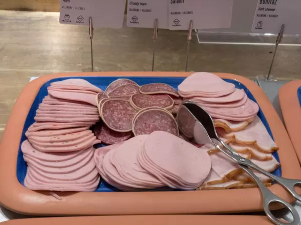 Wurstspezialitäten Aufschnitt an einem Buffet mit Zange zum bedienen - Kräterbraten, Salami und Kochschinken