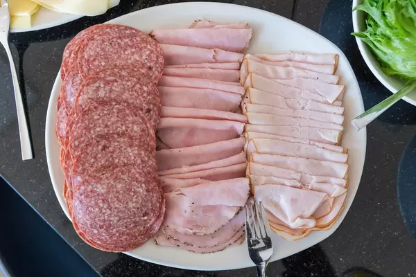 Wurstteller am Frühstücksbüfett mit verschiedenen Wurstsorten, wie Schinken und Salami, als deftiger Brotaufschnitt