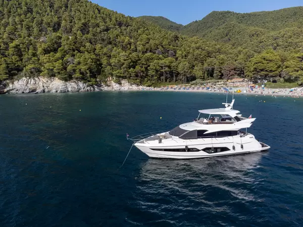 Yacht vor der Küste von Skopelos vor dem beliebten Kastani Strand, umgeben von bewaldeten Hügeln