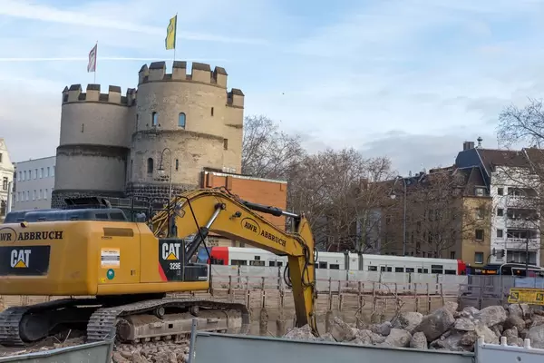 Yellow crawler excavator lift an excavation behind at Cologne Rudolfplatz