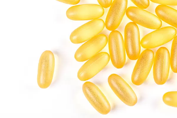 Yellow fish oil capsules on white background