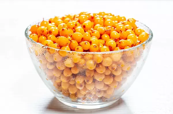 Yellow fresh sea buckthorn berries in glass bowl