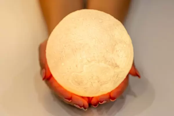 Yellow glowing ball-moon in women's hands