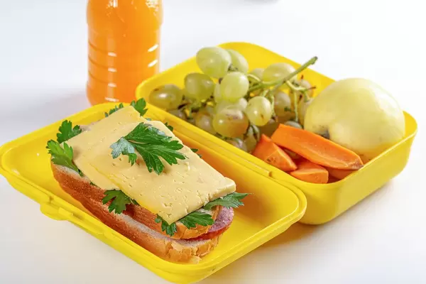 Yellow lunch box with lunch for a child at school