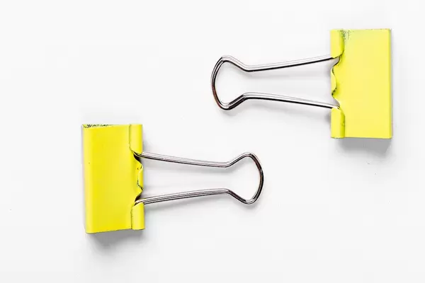 Yellow paper clip on white background (Flip 2019)