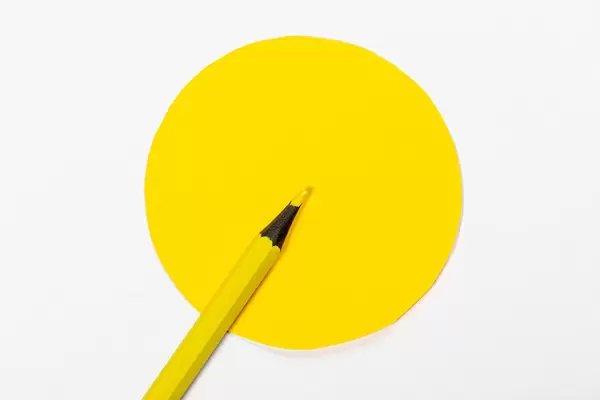 Yellow pencil and yellow circle on white background (Flip 2019)