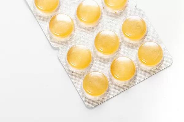 Yellow pills-lollipops in a blister on a white background (Flip 2019)