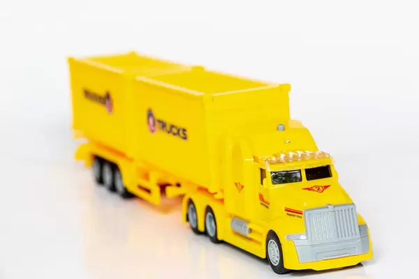 Yellow plastic toy car truck on white background