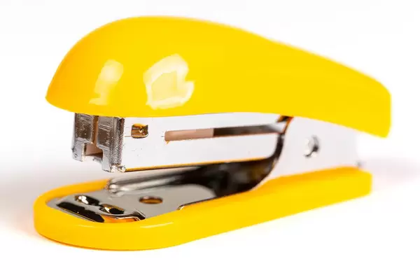 Yellow stapler on white background