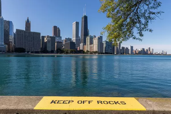 Yellow warning sign: "Keep off rocks" by the waters of Lake Michigan in Downtown Chicago