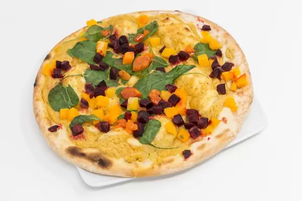 Yoga-Pizza Vegan von Followfood auf dem Teller vor weißem Hintergrund. Diese Pizza ist traditionell in Italien gebacken