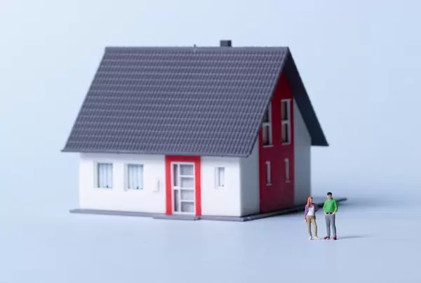 Young couple with house on a light blue background