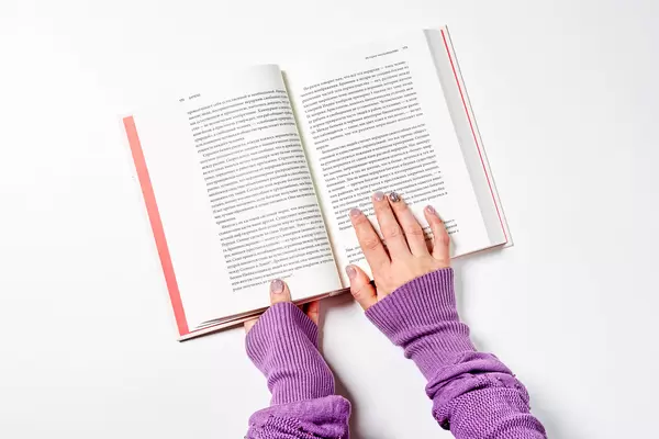 Young female in warm sweater reading a book