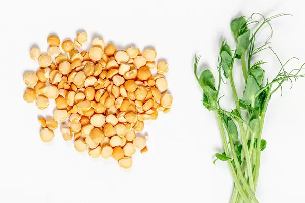 Young fresh pea sprouts and pea-grits on white background
