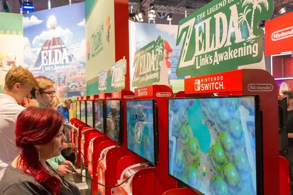 Young games fair visitors playing the Zelda Remake "Link's Awakening" on Nintendo Switch