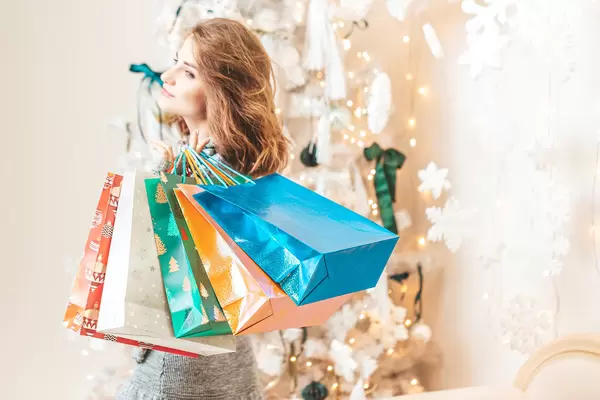 Young girl with gift bags in a light festive interior