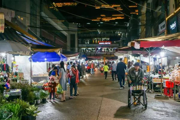 Young Man with a Wheelchair selling Lottery Tickets at a Street Night Market in Dalat, Vietnam