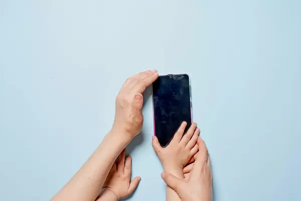 Young mother with her baby using smartphone