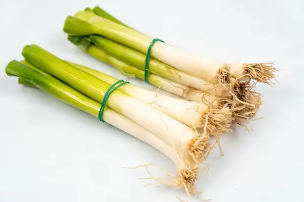 Young Onions on the white  wooden board (Flip 2020)