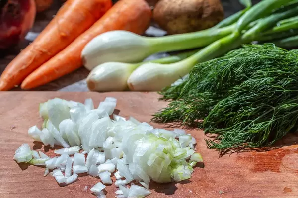 Young onions with fresh vegetables on the kitchen table (Flip 2019)