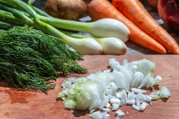 Young onions with fresh vegetables on the kitchen table