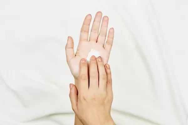 Young woman applying hand cream