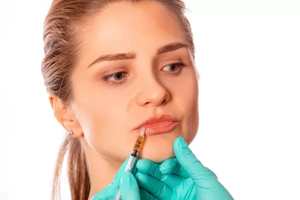 Young woman gets injection in her lips