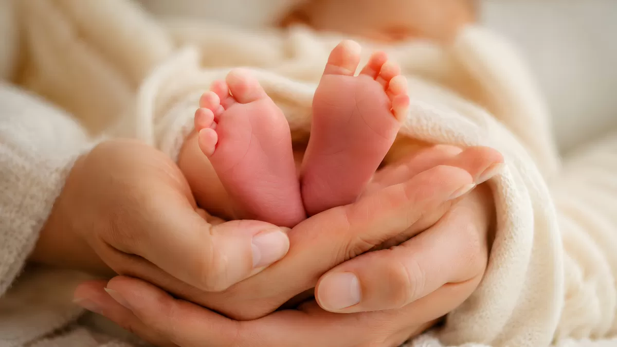 Zarte Babyfüße in liebevollen Händen gehalten