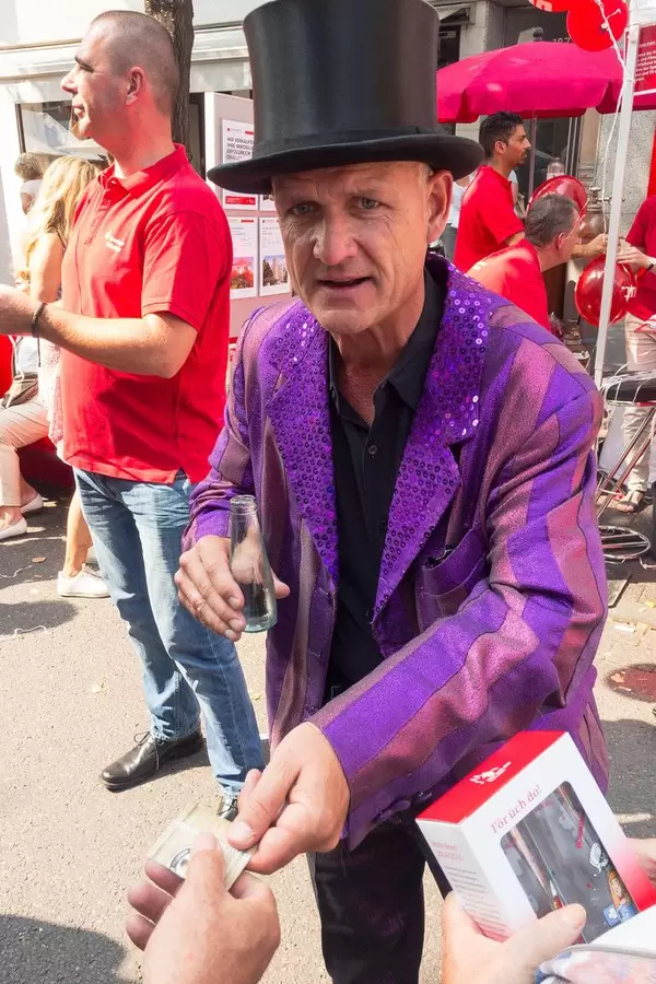 Zauberer mit Zylinderhut und lila Sakko