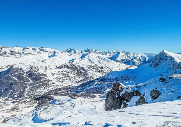 Zauberhafter Ausblick über verschneite Berggipfel im Winter bei strahlendem Sonnenschein in Vars, Frankreich