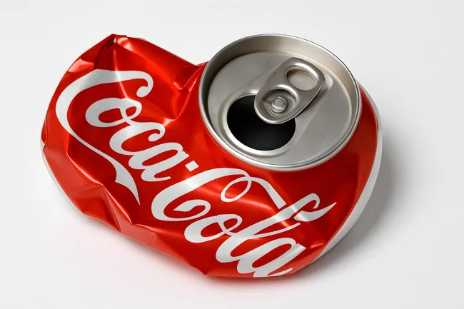 Zerdrückte Coca-Cola Dose auf weißem Hintergrund