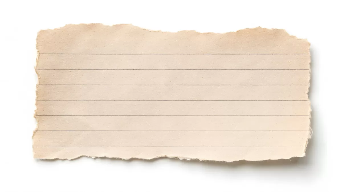 Zerissenes liniertes Notizbuchpapier auf weißem Grund
