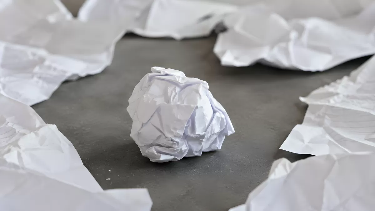 Zerknüllte Papierknäuel auf grauer Oberfläche