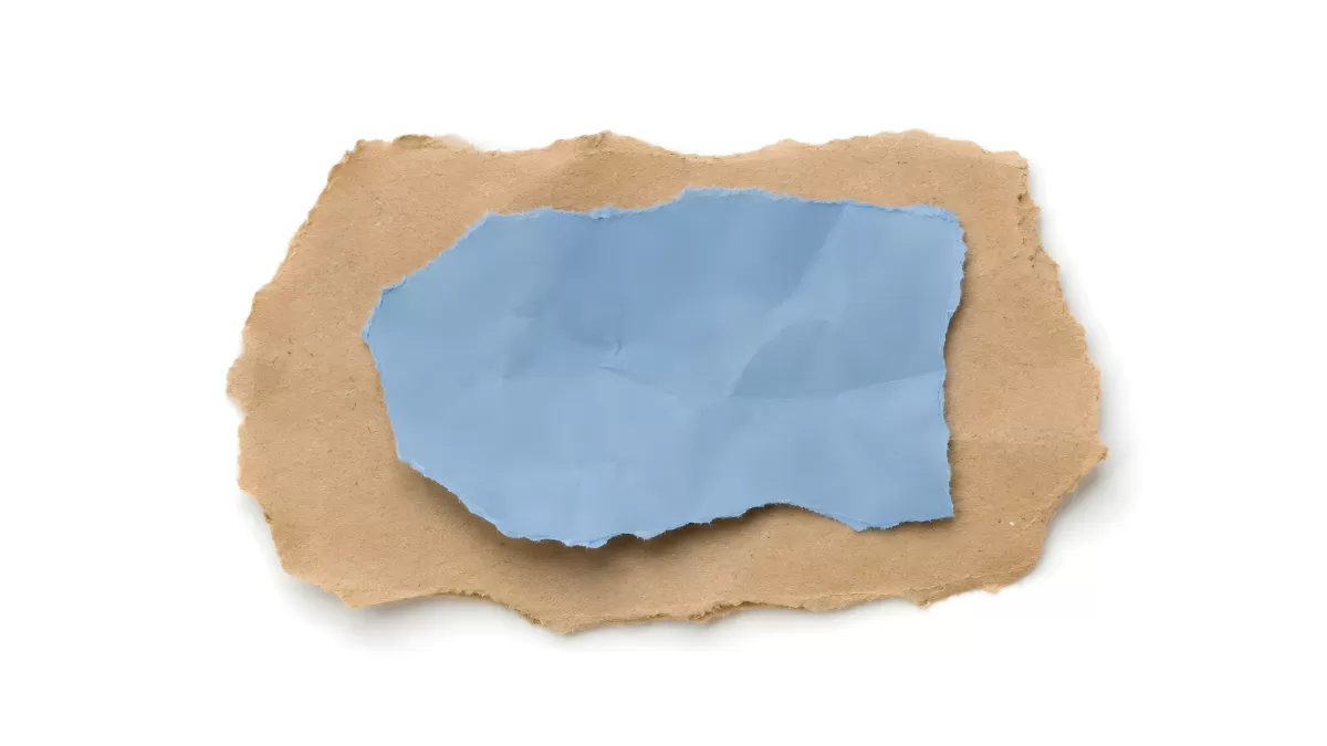 Zerrissenes Packpapier mit blauem Papierstück darunter