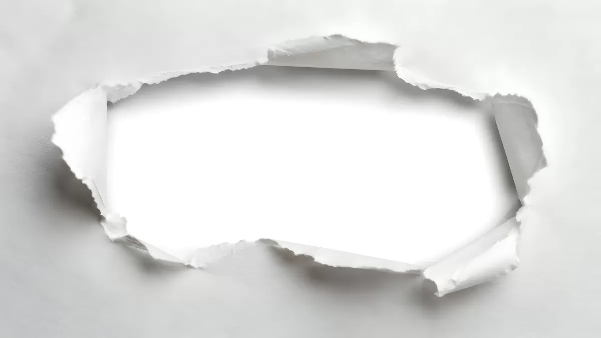 Zerrissenes Papier mit Loch in weißem Hintergrund